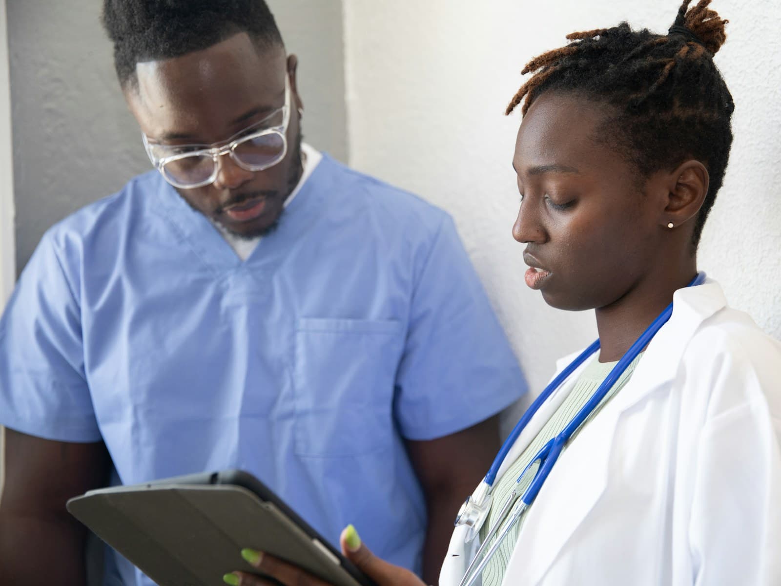 Two healthcare professionals reviewing a platform on a tablet